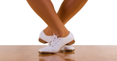 An individual's legs wearing clogging shoes.